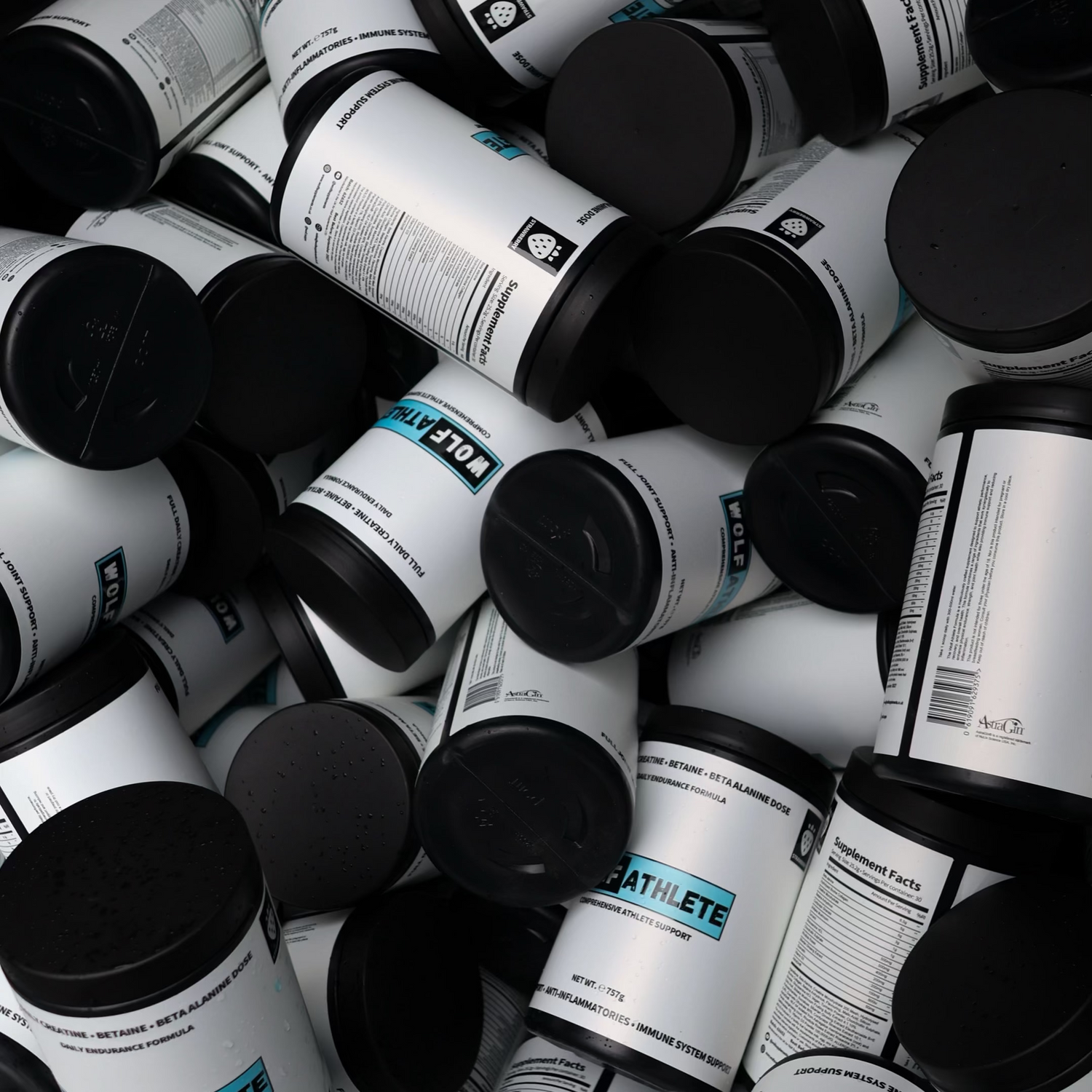 Pile of cylindrical containers with black lids and visible labels.
